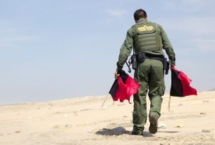 US Border Patrol member sets out market flags.